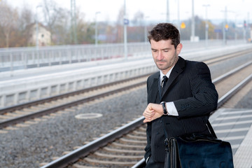 man in suit on business trip is looking on his watch