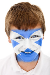 Young boy with Scottish flag painted on his face