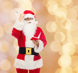 man in costume of santa claus with notepad