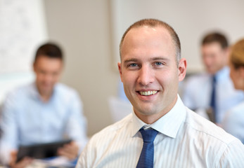 group of smiling businesspeople meeting in office