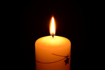 White christmas candle burning on a black background
