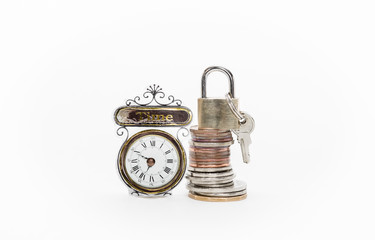 money coins stack with padlock and keys on top beside a clocks
