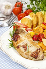 Joint of pork with baked potatoes and fresh vegetables