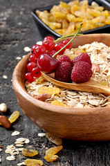 Oat flakes and fresh berries in a wooden bowl