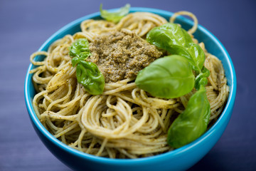 Close-up of spaghetti with pesto sauce in a glass bowl