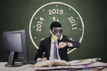 Worker wearing gas mask and looking timepiece