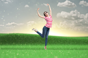 Young dancing girl with arms up in the park. Fashion model