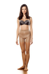 Fototapeta premium young woman in nylon stockings and bra on a white background