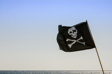pirate flag waving with blue sea background