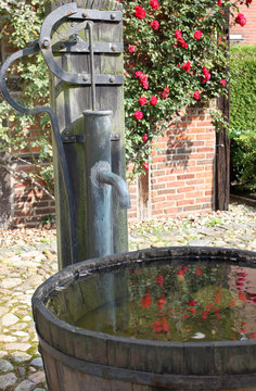 Old water tap with big water bucket