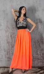 Young brunette woman in long orange skirt