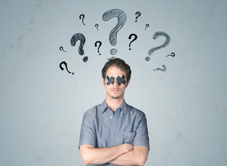 Young man with glued eye and question mark symbols
