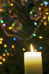 Flame of candle and Christmas tree ornaments.