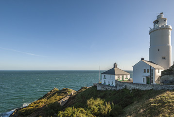 Fototapeta na wymiar A British lighthouse on the headland at Start Point