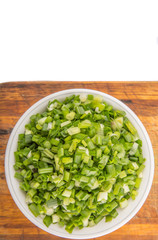 Chopped scallion or spring onion leaves in a white bowl