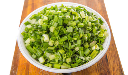 Chopped scallion or spring onion leaves in a white bowl