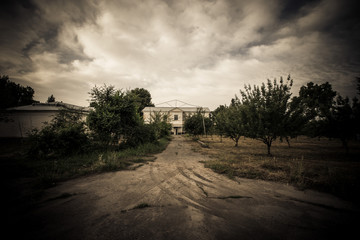 Dramatic road to house. Tajikistan. In dark colors