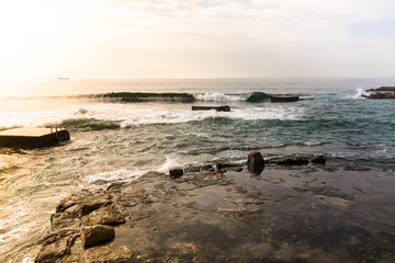 Fototapeta na wymiar Waves on the stone coast at dawn