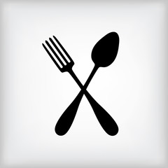 Crossed spoon and fork on gray background