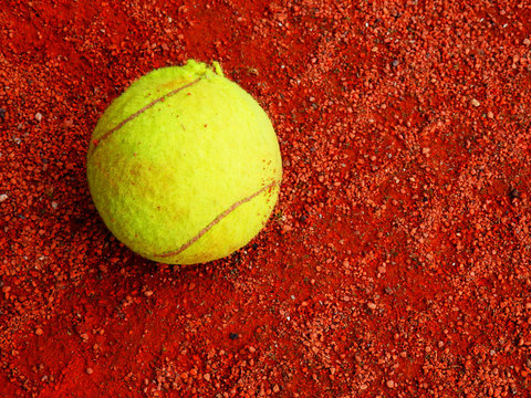 Tennis Ball Detail On Red Clay Court