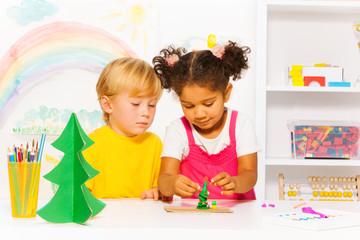 Boy and girl making forms of playing dough