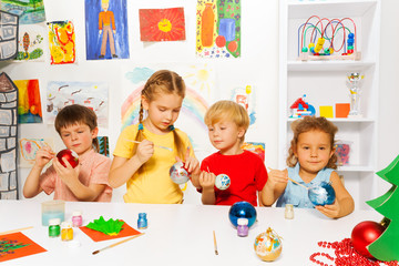 Group of kids paint New Year balls for Xmas tree