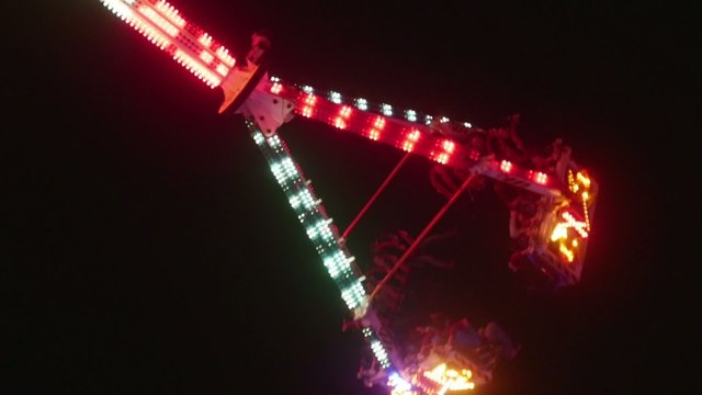 Large swinging ride in motion with people screaming at night