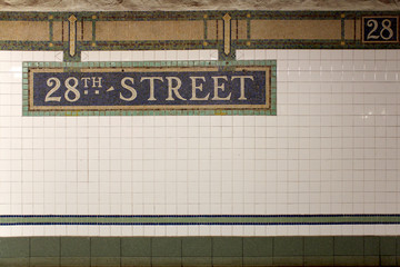 Naklejka premium New York City Station subway 28th Street sign on tile wall.