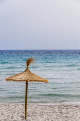 Straw umbrella on sand beach.