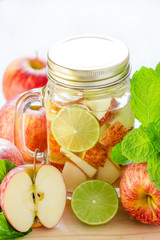 Mug delicious refreshing drink of apple fruits with mint on wood