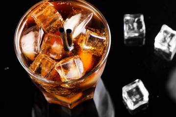 A full glass of cola with ice cubes