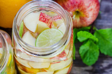 Mug delicious refreshing drink of mix fruits with mint on wooden