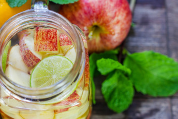 Mug delicious refreshing drink of mix fruits with mint on wooden