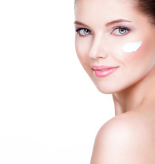 Naklejka premium Young woman with cosmetic cream on a clean fresh face.
