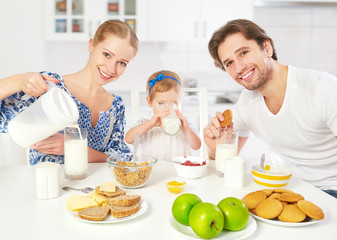 Happy family mother, father, child having breakfast