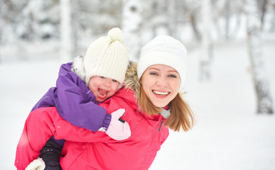 Fototapeta na wymiar happy family mother and baby girl daughter playing in winter