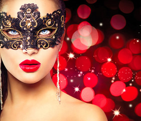 Woman wearing carnival mask over glowing red background