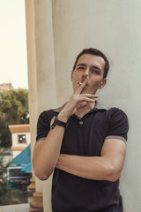 Fototapeta na wymiar Handsome young man smoking cigarette