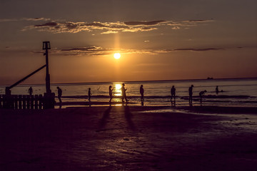 Sunset and people silhouettes at the Seaside