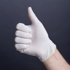 Male hand in latex glove (thumb up sign)