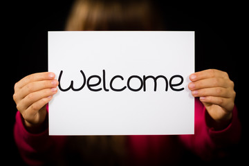 Child holding Welcome sign