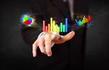 Handsome young business man touching colorful modern graph syste