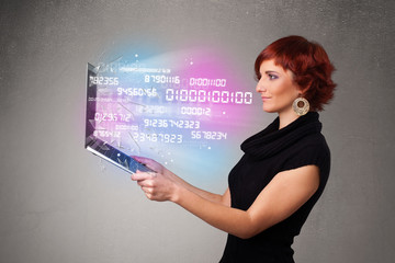 Casual woman holding laptop with exploding data and numers