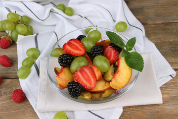 fresh tasty fruit salad on wooden table