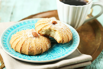 Cup of coffee with tasty cookie on color wooden background