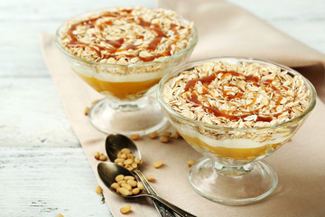 Tasty dessert with oat flakes and honey, on table