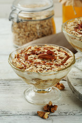 Tasty dessert with oat flakes and honey, on table