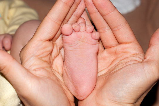Baby foot in mother's hands