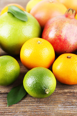 Ripe citrus with green leaves on wooden background