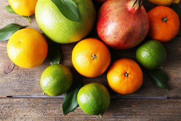 Ripe citrus with green leaves on wooden background
